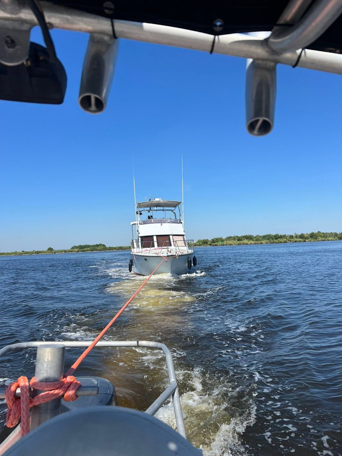 TowBoatUS Sabine Lake towing vessel assisting a white sport fishing boat on Sabine Lake with a red tow line visible.
