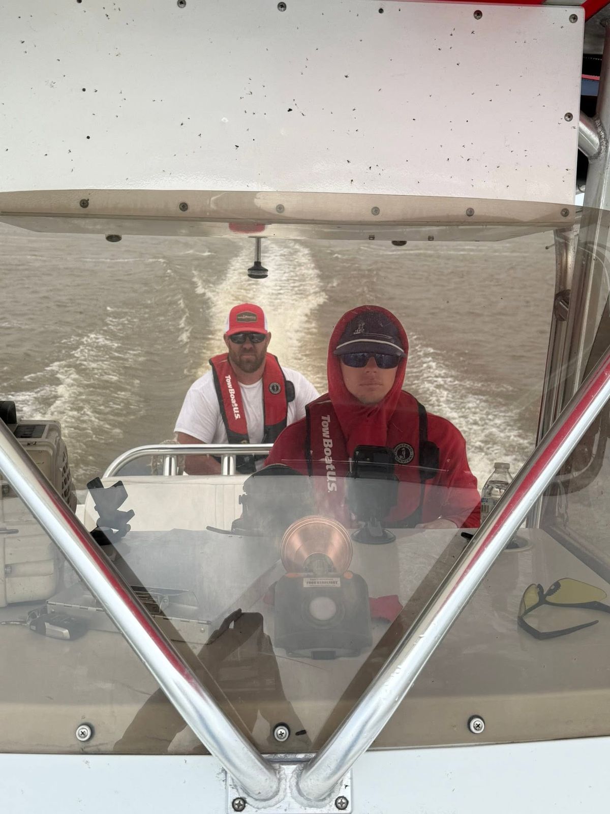 Two TowBoatUS Sabine Lake crew members operating a service boat on Sabine Lake under the canopy during daytime operations.
