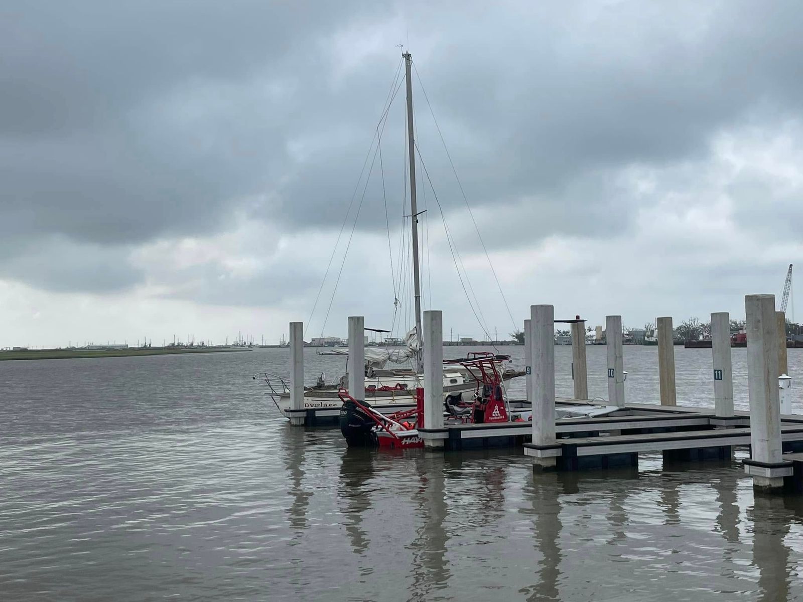 TowBoatUS Sabine Lake vessels moored at the wooden pier, including red and black towing boats.